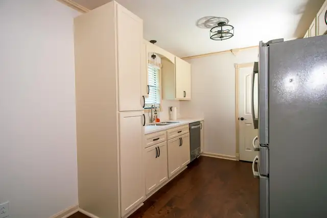 Complete kitchen remodel with Shaker style cabinets in Almond, new countertops and stainless appliances