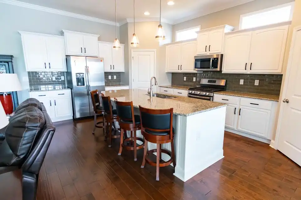 Cabinet refacing Wilmington NC: kitchen refaced with Temptation and Freedom style doors in Bisque, a granite island and bar seating
