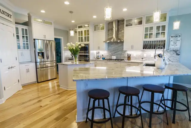 Replacement cabinets in Cottage style White Satin with glass-front uppers and a granite island with stools