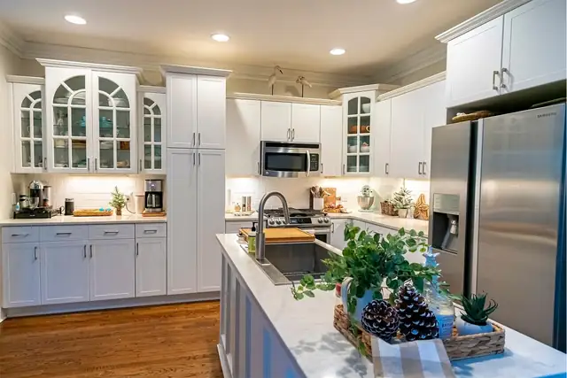 White Satin Carolina Shaker cabinet doors with arched glass uppers and a kitchen island